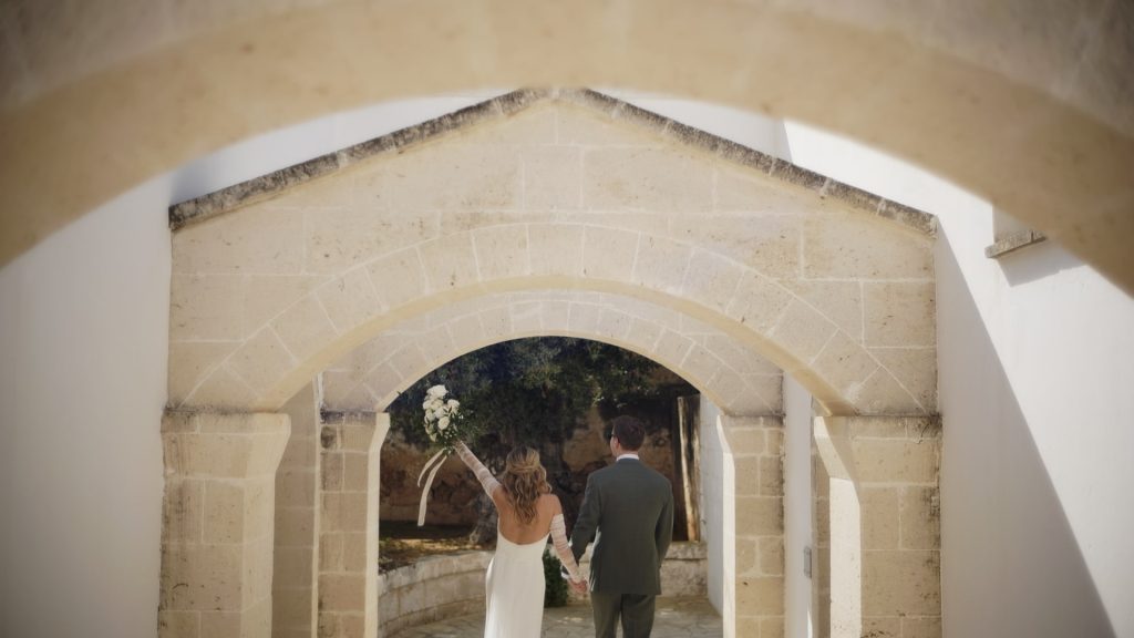 couple rejoicing while walking along an avenue of the masseria in Puglia