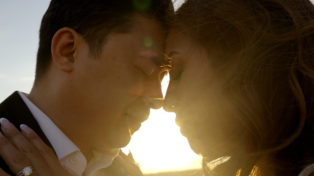 American couple face to face with eyes closed at sunset before their destination wedding in Italy