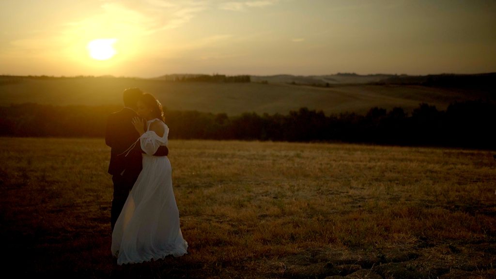 hug of a couple at sunset among the Tuscan landscape during their save the date shooting before their destination wedding