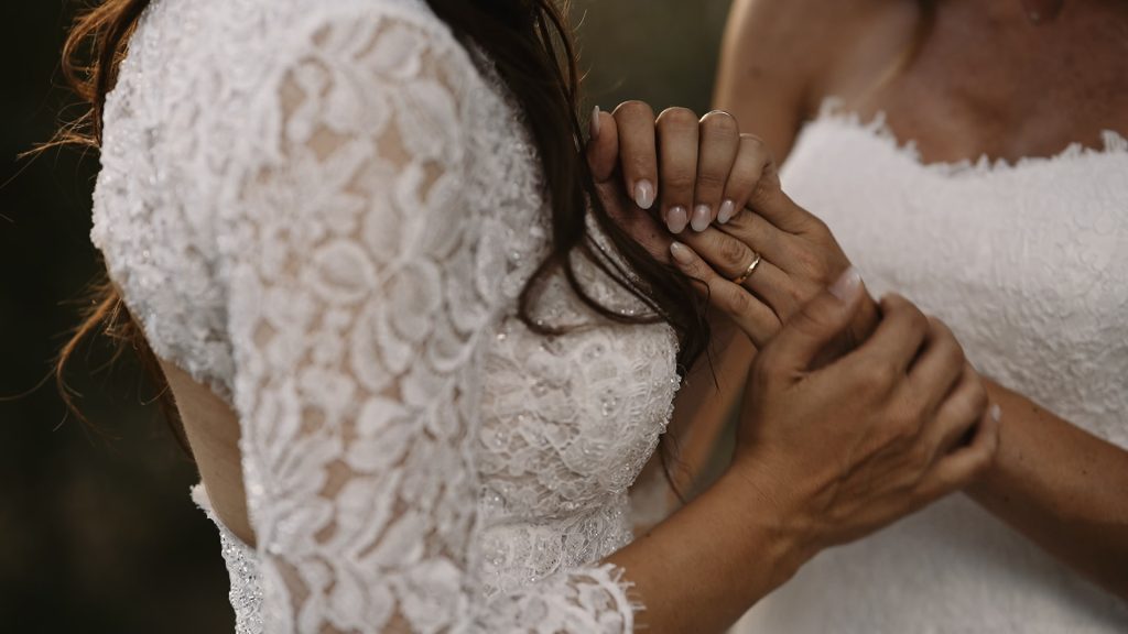 detail of the brides' hands caressing each other and the wedding ring
