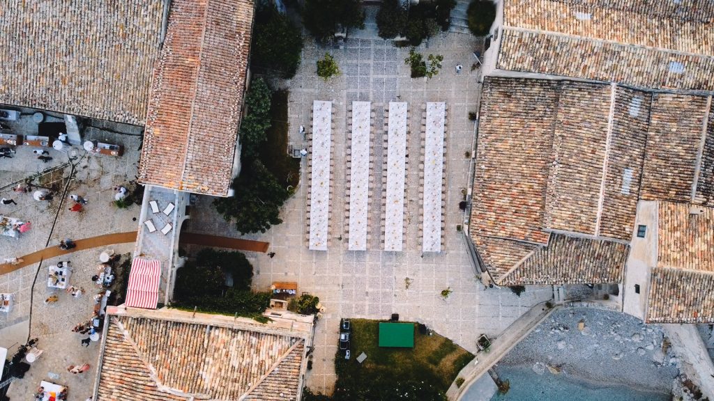 set up of four imperial tables in the courtyard of the Tonnara di Scopello
