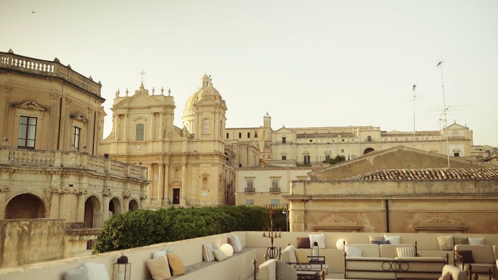panoramic view of the cathedral of Noto and some baroque buildings from the terrace of a hotel in the center during Christophe and Lynn welcome dinner the day before their destination wedding