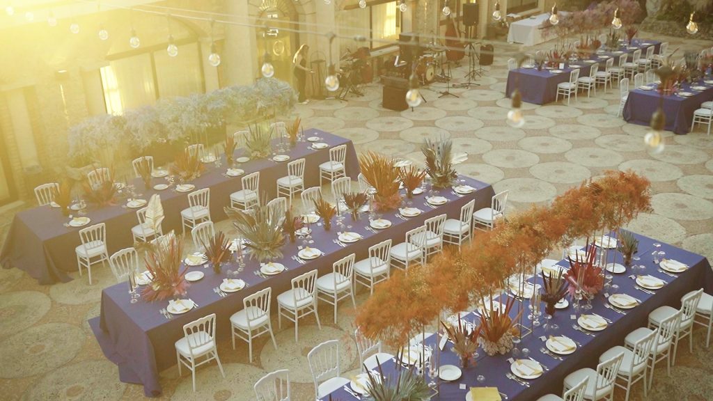 setting up tables fro dinner in Caribbean style and multicolored in the courtyard of a Venue at sunset