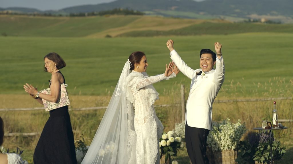 the newlyweds rejoice among the green Tuscan landscape they have said yes during their destination wedding in Tuscany