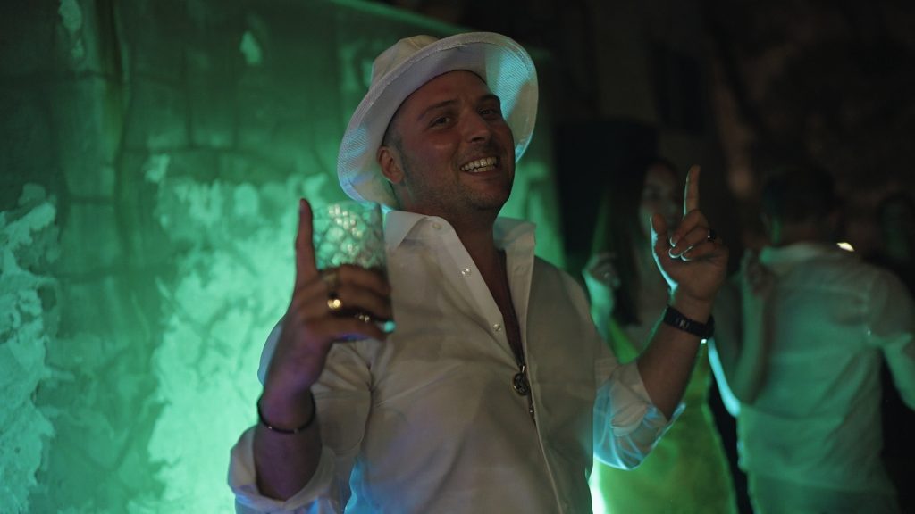 guest dancing smiling while drinking a cocktail
