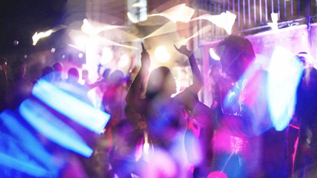 the bride and groom dance among the psychedelic lights of their party