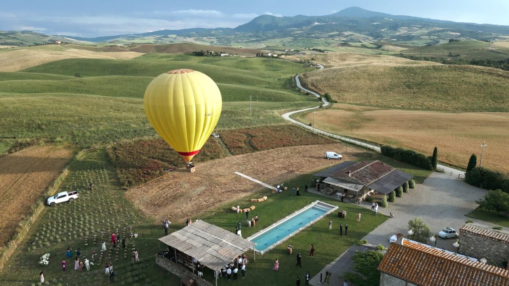 panoramic view of a Tuscan estate between the verdant hills and with hot air balloon