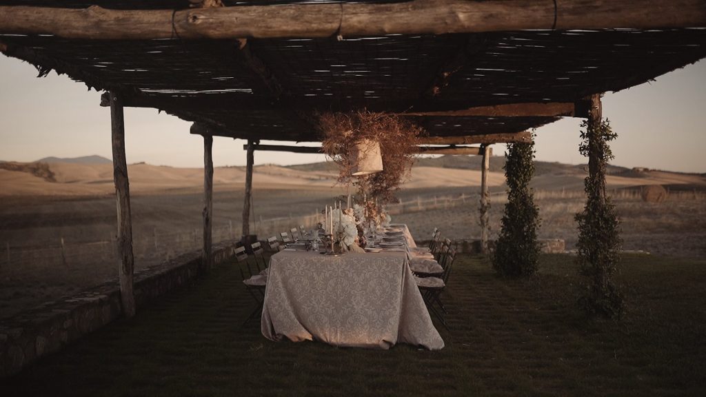 table set under a pergola in the Tuscan countryside