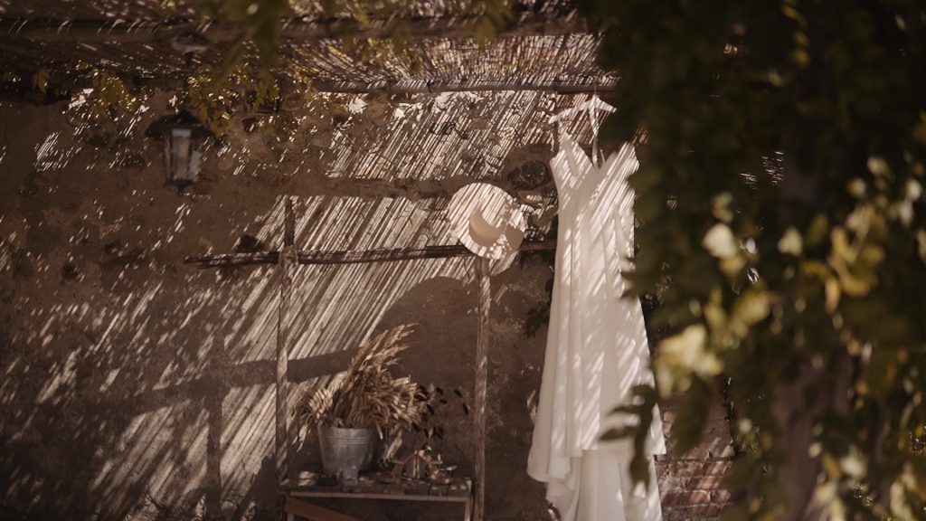 bride's dress and hat under the pergola of a Tuscan farmhouse
